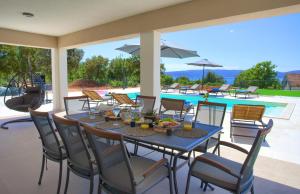 a patio with a table and chairs and a pool at Villa MAGNIFICA with pool in Pinezici