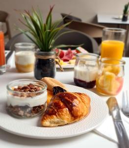 a table with a plate of breakfast foods and drinks at Hôtel Amirauté in Toulon