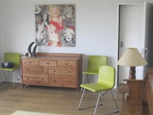 a living room with a dresser and green chairs at Casa do Açor in Linhares