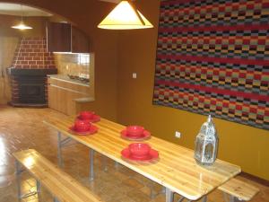 a kitchen with a table with red dishes on it at Casa do Açor in Linhares