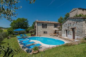 uma vista exterior de uma casa de pedra com uma piscina em Villa Colombaia em Acqualagna
