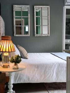 - une chambre avec un lit et une table avec une lampe dans l'établissement Driftwood Suite, Villa Roc Guesthouse , Ballito, Salt Rock- No loadshedding, à Sheffield Beach