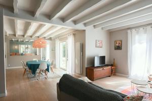 a living room with a couch and a table at Villa Pinkmary Pour 10 Personnes in Hossegor