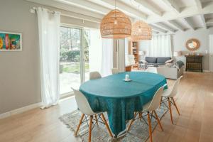 Villa Pinkmary Pour 10 Personnes في هوسيغور: غرفة طعام مع طاولة وكراسي زرقاء