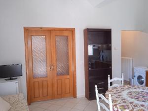 um quarto com uma porta, uma cama e uma televisão em Sotiris house em Preveza