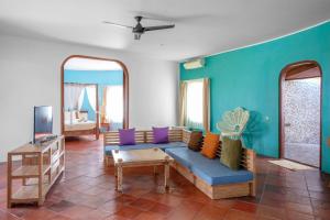 a living room with a blue couch and mirrors at Whales and Waves in Lemonga