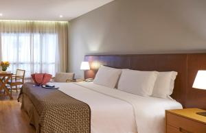 a hotel room with a large bed and a desk at PortoBay Rio de Janeiro in Rio de Janeiro