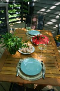 una mesa de madera con platos de comida y copas de vino en Baumhaus Silent, 