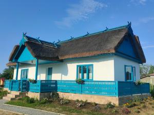 une maison bleue et blanche avec une clôture bleue dans l'établissement Gorgova Delta Village, à Gorgova