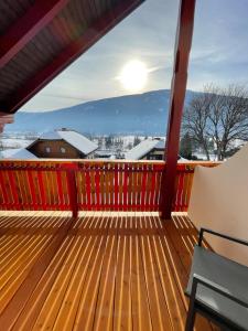 a balcony with a wooden deck with the sun in the sky at Landhaus Metzgerstubn in Sankt Martin