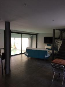 ein Wohnzimmer mit einem blauen Sofa und einer Treppe in der Unterkunft Castel&Letti in Agde