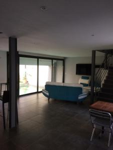 salon z niebieską kanapą i schodami w obiekcie Castel&Letti w mieście Agde