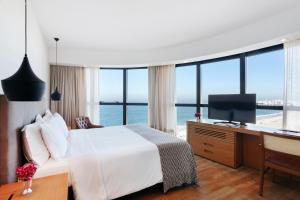 a bedroom with a bed and a desk with a computer at PortoBay Rio de Janeiro in Rio de Janeiro