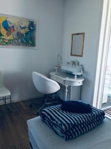 Habitación con lavabo, cama y silla en Seaview and Swimming, en Hellerup