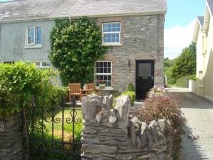 a stone fence in front of a house at Carrig Beag in Kenmare