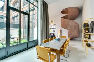 ein Esszimmer mit einem Tisch und Stühlen sowie einem großen Fenster in der Unterkunft Sweet Inn - Brune in Paris