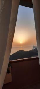 NebidaにあるVista Sul Pan di Zucchero - Nebida - Holiday Houseの窓から夕日を望む