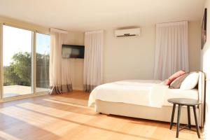 a white bedroom with a bed and a balcony at Gorgeous Mansion by Caesarea's Greatest Beach-hosted by Sweetstay in Caesarea