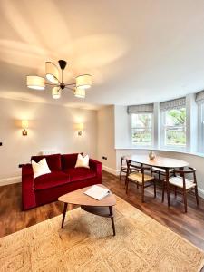 sala de estar con sofá rojo y mesa en Redland Suites - Apartment 2, en Bristol