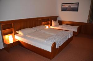 2 Betten in einem Zimmer mit Beleuchtung in der Unterkunft Hotel Krmstl "Zur Stadt Gmunden" in Kirchdorf an der Krems