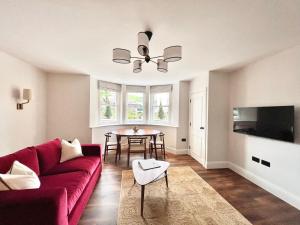 sala de estar con sofá rojo y mesa en Redland Suites - Apartment 2, en Bristol