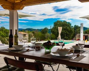 a wooden table with wine glasses and a bowl of fruit on it at Villa Klara in Buzet