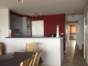 - une cuisine avec une table à manger et un mur rouge dans l'établissement Apartment Helena 4, à Blankenberge