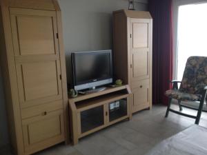 - un salon avec une télévision et un meuble de rangement dans l'établissement Apartment Helena 4, à Blankenberge
