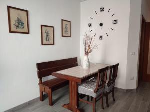 mesa de comedor y sillas con reloj en la pared en Appartamento centrale, en SantʼAntìoco