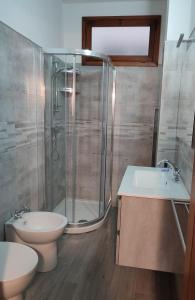 y baño con ducha, aseo y lavamanos. en Appartamento centrale, en SantʼAntìoco