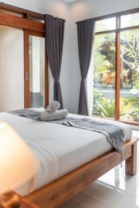 uma cama num quarto com uma janela em D'bunut villa ubud em Ubud