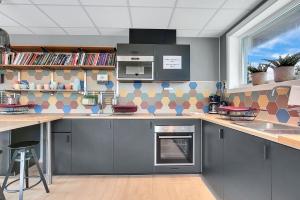 a kitchen with grey cabinets and a sink and a window at Ballangen Camping in Narvik