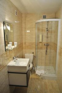 a bathroom with a shower and a sink and a toilet at Hotel Krystyna in Szczytno