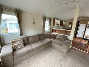 un soggiorno con divano e alcune finestre di 2-Bedroom Parkhome in Uddingston, Glasgow a Uddingston