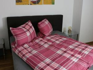 ein Bett mit zwei rosa Kissen darüber in der Unterkunft Ferienhaus Ochsenauge in Weimar