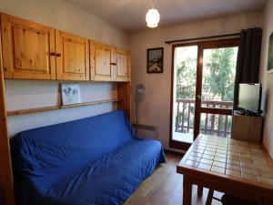 een slaapkamer met een blauw bed, een tafel en een raam bij Appartement Arêches-Beaufort, 2 pièces, 4 personnes - FR-1-342-182 in Arêches