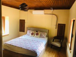 1 dormitorio con 1 cama y 1 silla en Lovely house in the heart of nature, en Serik