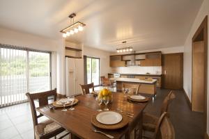 una sala da pranzo e una cucina con tavolo e sedie in legno di Arte da Fuga a Lajes do Pico