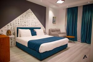 开罗Elite Pyramids Boutique Hotel的带一张大床和一把椅子的卧室