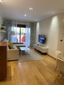 - un salon avec un canapé et une télévision dans l'établissement Apartamento Lujo PLAYAGRANADA, Blue&Green, à Motril