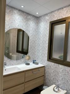 ein Badezimmer mit Waschbecken und Spiegel in der Unterkunft Apartamento Lujo PLAYAGRANADA, Blue&Green in Motril