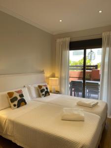 ein Schlafzimmer mit einem großen weißen Bett und einem Balkon in der Unterkunft Apartamento Lujo PLAYAGRANADA, Blue&Green in Motril + 14 Fotos