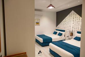 a bedroom with two beds with blue and white at Elite Pyramids Boutique Hotel in Cairo