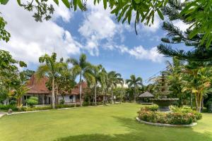 un giardino di fronte a una casa con palme di S Resorts Hidden Valley Bali a Uluwatu