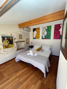 a bedroom with a bed and paintings on the wall at Fenêtre sur Collioure in Collioure