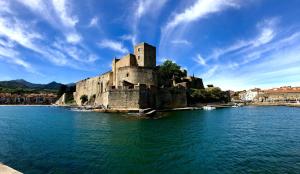 a castle in the middle of a body of water at Fenêtre sur Collioure in Collioure
