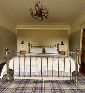 a bedroom with a metal bed with a chandelier at Ashtree House Hotel, Glasgow Airport & Paisley in Paisley