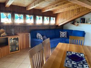 uma sala de estar com um sofá azul e uma mesa em Casa Belvedere em Pieve di Cadore