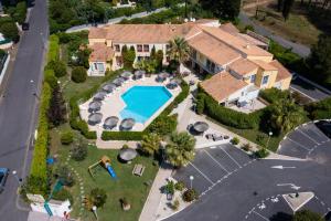 an aerial view of a house with a swimming pool at Hotel Hélios in Cap d'Agde