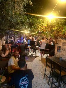 un grupo de personas sentadas en un bar por la noche en Kuyu Beergarden Hostel, en Antalya